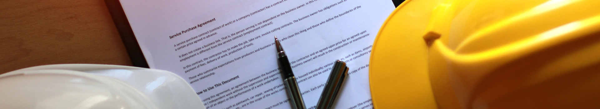 Kask oraz długopis leżące na dokumencie
