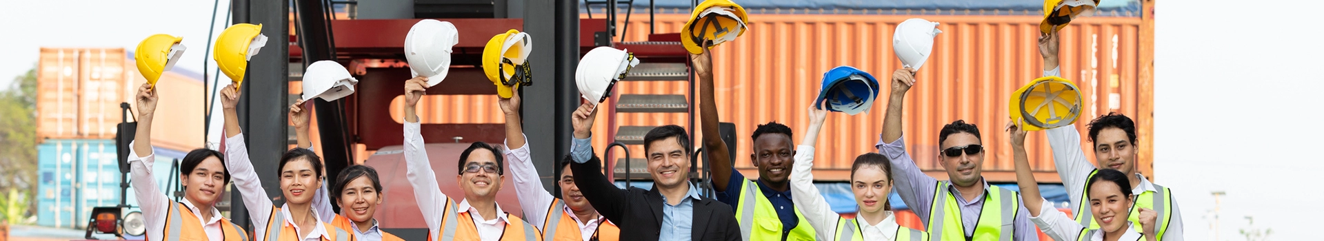 Pracownicy trzymający kaski nad głowami
